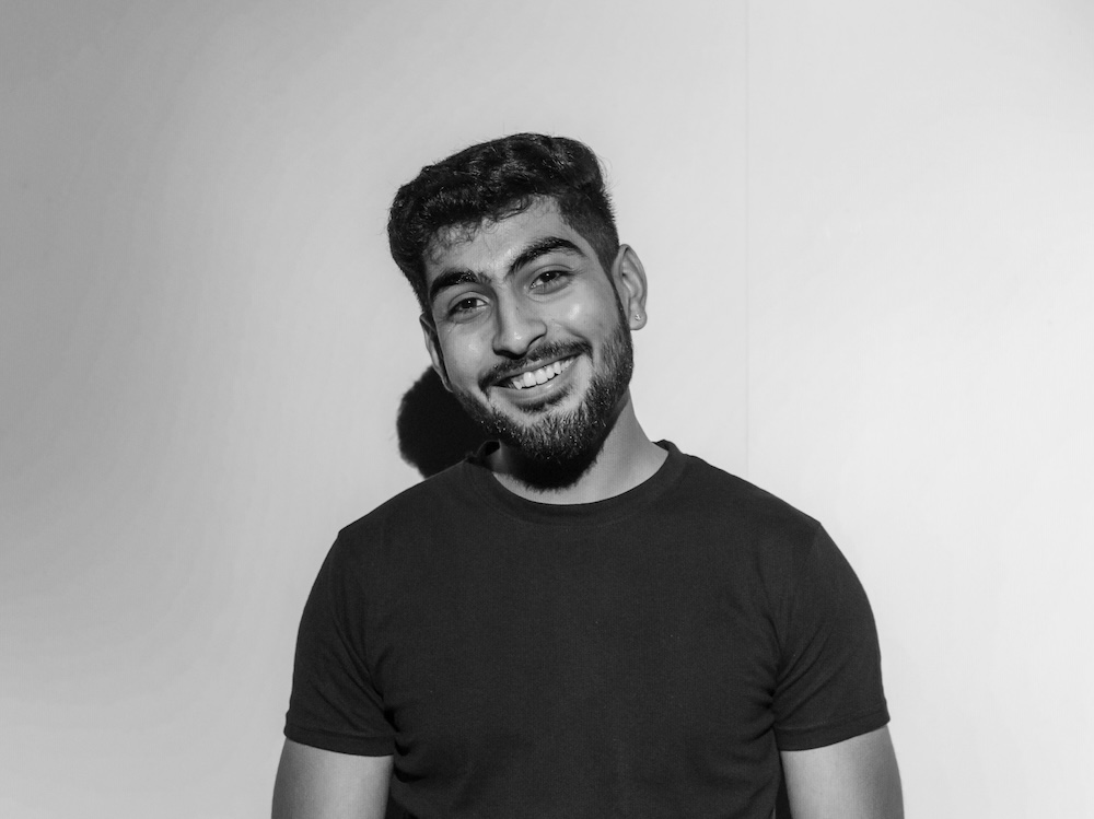 A black and white headshot of a man smiling