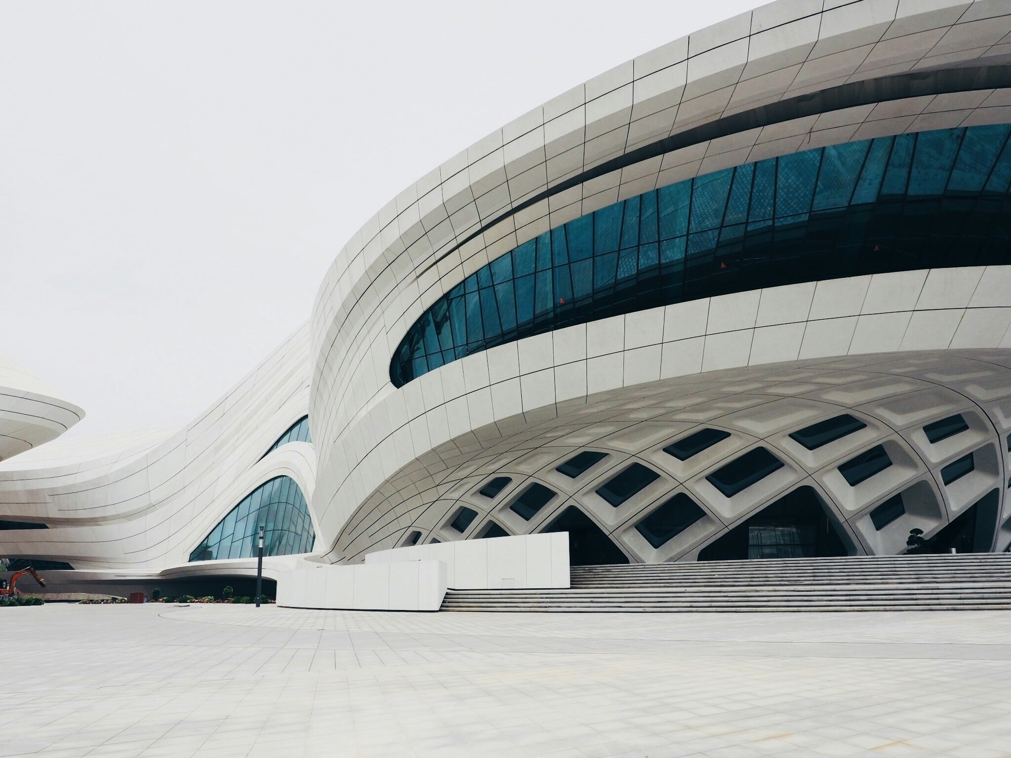 Futuristic white building with curved lines and large, geometric window panes.